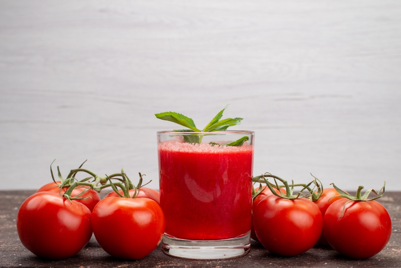 front-view-fresh-tomatoe-juice-with-leaf-along-with-whole-tomatoes-grey-vegetable-fruit-color-cocktail (1)