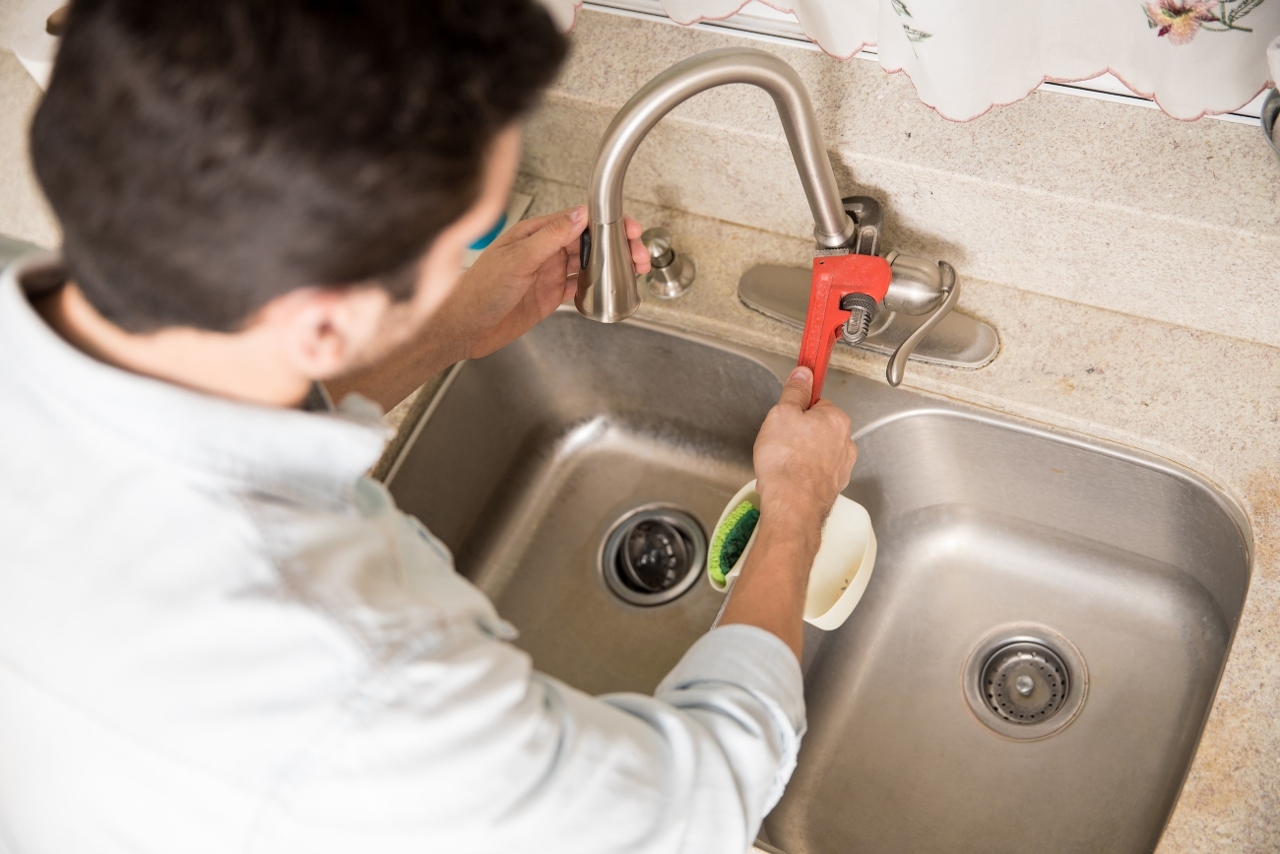 male-plumber-using-wrench-tighten-water-faucet-kitchen-seen-up-close (1)